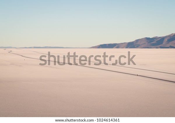 Landscape of the Uyuni salt flat,\
Salar de Uyuni. Cars in the road, side comparission.\
bolivia