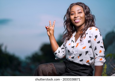 landscape view of beautiful african lady, with a two sure sign, cheerful black woman outdoor  - Shutterstock ID 2033338871