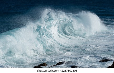 Landscape view of blue rolling wave slamming on volcanic stones of the coastline like a tsunami. Beautiful spray due to the wind. Costa Teguise, Lanzarote, Canary Islands, Spain.	
 - Shutterstock ID 2237801805
