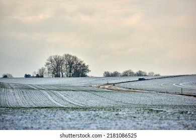 Landscape view of an empty and secluded field covered in snow during winter in Denmark. Beautiful and peaceful scenery of a cold and snowy day on agricultural land in the countryside with copy space