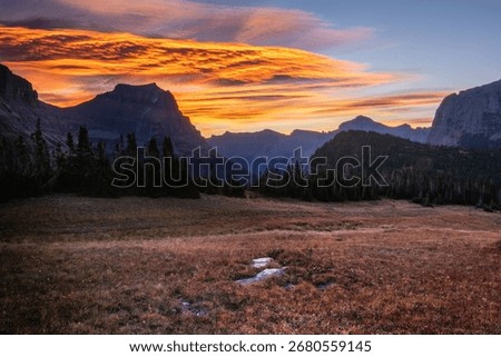 A landscape view of the Logan Pass elevation in Montana with mountains in the background during the sunset