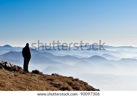 Landscape view of misty autumn mountain hills and man silhouette