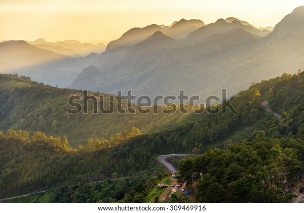 landscape view of mountain , tent , road in forest with\
sunset scene 