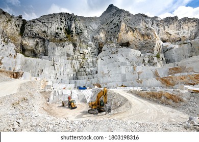 Landscape view of an open cast marble quarry in Carrara, Tuscany, Italy showing the heavy duty equipment and rock face