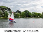 Landscape view of South Norwood lake where children can be seen practicing water sport activities such as sailing