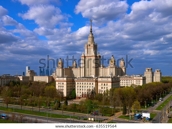 A landscape view of the\
sunny spring campus of Lomonosov Moscow State University under blue\
cloudy sky