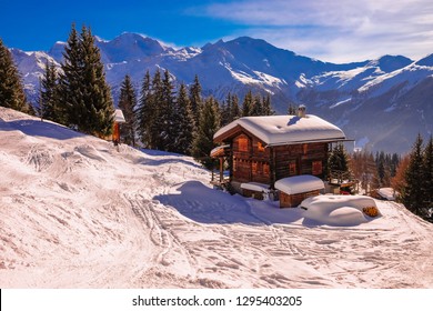 Landscape View Of A Traditional Wooden Chalet With Snowy Alps In The Background , In The Ski Resort Of 