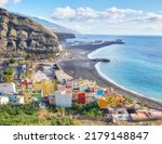 Landscape view of vibrant residential buildings, sea and ocean, a blue sky with clouds and copy space. Scenic mountain and black sand beach of coastal city of Puerto de Tazacorte in La Palma, Spain