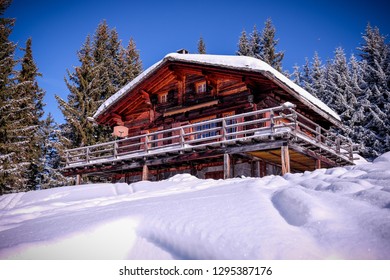 Landscape View Of A Wooden Chalet With Its Roofs And Balcony Covered By Snow, In The Ski Resort Of 