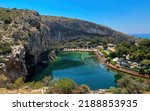 Landscape with volcanic lake Vouliagmeni with azure water and radon located 25 km from the center of Athens and 100 meters from the sea. Sunny day.