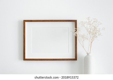 Landscape Wooden Frame Mockup With Copy Space For Artwork, Photo Or Print Presentation. White Wall And Vase With Dry Gypsophila Flower Decoration.