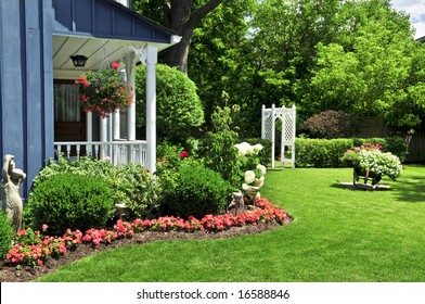 Landscaped Front Yard Of A House With Flowers And Green Lawn