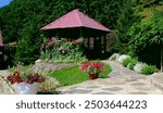 Landscaped garden with terrace, Wooden gazebo and patio decorated summer flowers. Cottage and vacations, mountain hotel resort