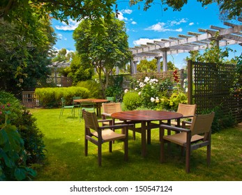 Landscaped Garden With Wooden Dining Table Set In The Shade Of Trees