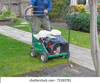 Landscaper With Lawn Mower In Residential Garden