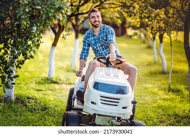 Landscaping Details - Portrait Of Gardener Smiling And Mowing Lawn, Cutting Grass In Garden