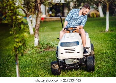 Landscaping Details - Portrait Of Gardener Smiling And Mowing Lawn, Cutting Grass In Garden