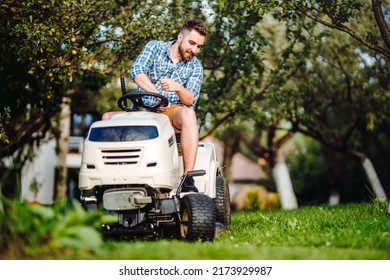 Landscaping Details - Professional Gardener Smiling And Mowing Lawn, Cutting Grass In Garden