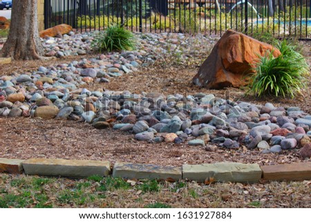 Landscaping with a dry stream and using river rock to accent garden