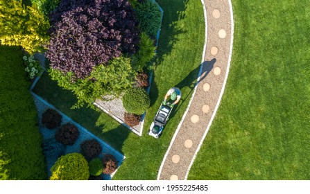 Landscaping Job Grass Mowing Aerial View. Caucasian Gardener with Grass Mower Inside Large Beautiful Backyard Garden. - Shutterstock ID 1955225485
