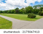 Landscaping of a parking area with flowers and trees on a sunny day, an ennobled park area in a botanical garden with paths and green trees