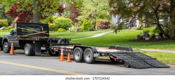 Landscaping Truck With Empty Flatbed Trailer With Ramp Parked On Residential Neighborhood Street.