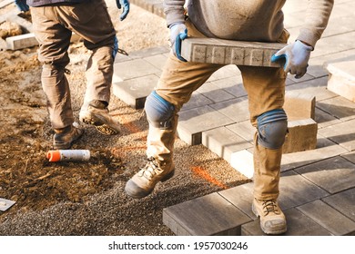 landscaping workers laying paving stones at residential home for quality interlock, garden and home renovation project. Spring is good season to hire contractors for the home improvement around house.