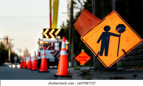 Lane Closure On A Busy Road Due To Maintenance, Signs Detour Traffic Temporary Street Work Orange Lighted Arrow, Barrels And Cones.