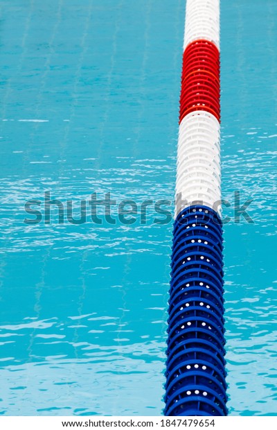 Lane
divider, pool marker lines. Line dividers pool. Blue, red and
white. Blue clean water. Vertical
background.