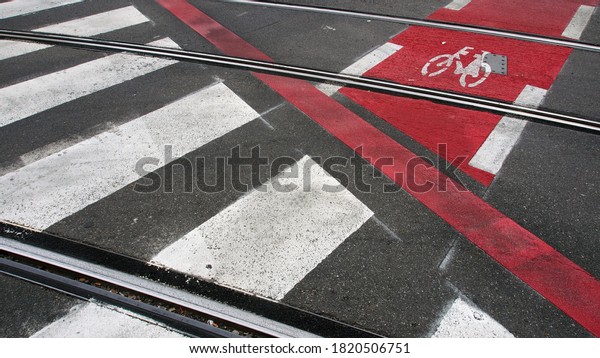 Lane markings of a bicycle lane,\
a zebra crossing and tram rails crossing, urban\
traffic