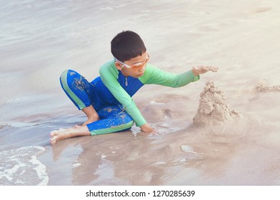 Langkawi Island, Malaysia - December, 2018: Asian Boy Building Sand Castle On Tropical Beach. 
