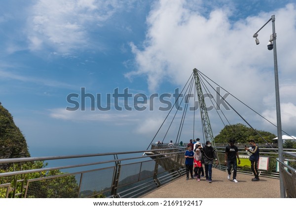 Langkawi, Kedah  Malaysia - March 5, 2022: Visitors\
walks on Langkawi Skybridge during clear weather, partially cloudy\
blue sky during daytime. Closed circuit tv cctv added for the\
security of visit