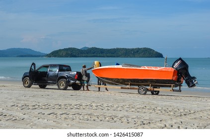 Langkawi, Malaysia - May 1, 2018. People Driving Tractor Go To The Sea For Keeping And Move Up Speed Boat Go To Store.