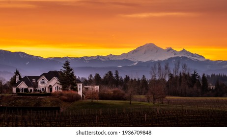 Langley, BC, Canada - March 13, 2021: Orange and Yellow Sky at Sunrise in the Fraser Valley of British Columbia, Canada with Mount Baker, a dormant volcano in Washington State, on the horizon
