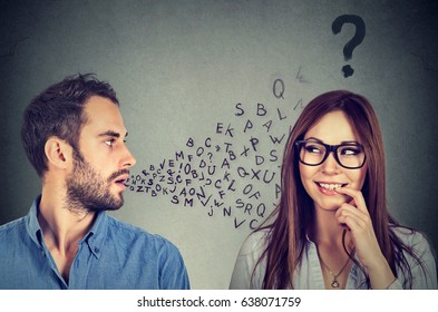 Language barrier concept. Handsome man talking to an attractive young woman with question mark 