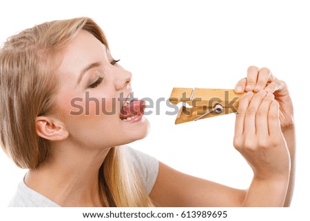 Language barrier, rumors, problems with expressing concept. Blonde woman having tongue in clothespin