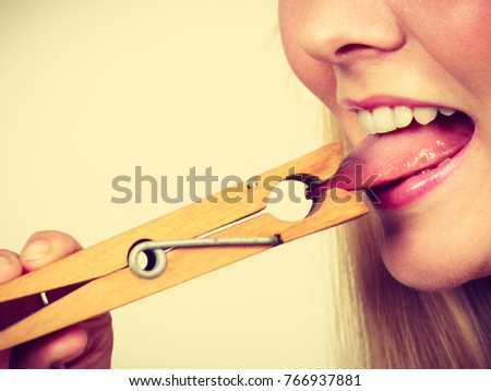 Language barrier, rumors, problems with expressing concept. Blonde woman having tongue in clothespin