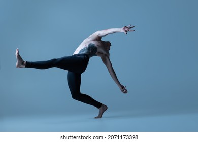 Language of body. Portrait of young man, flexible male ballet dancer dancing isolated on old navy background. Art, motion, action, flexibility, inspiration concept. Flexible artist. Beauty of male