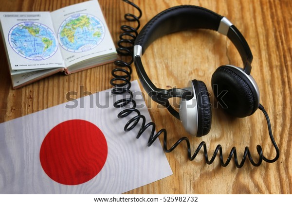 language course\
headphone and flag on wooden\
table