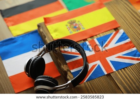 Language Learning Concept with Flags and Headphones on Wooden Table
