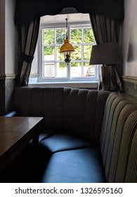 LANGWITH, UK - FEBRUARY 16, ‎2019: Window Banquette Seat And Table In An English Pub With Natural Light From The Window, In Summer