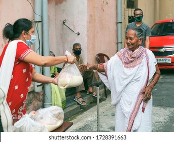 Lansdowne, Kolkata, 05/10/2020: Civic Volunteers Of A Social Welfare Association Giving Food Aid To An Old Lady During Coronavirus Lockdown In City. There Is Happiness And Smile In Her Face.