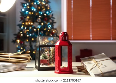 Lantern and letters on table in room decorated for Christmas