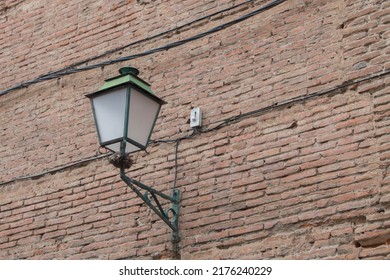 Lantern On A Brick Wall In A Street In Alcalá De Henares, Province Of Madrid. Spain