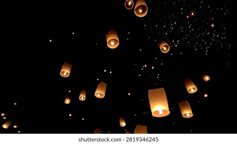Lanterns fill the sky as they float gracefully in the air. Many paper lanterns are released into the night sky to commemorate a certain day.