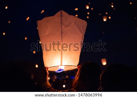 Lanterns are released into the night sky. 