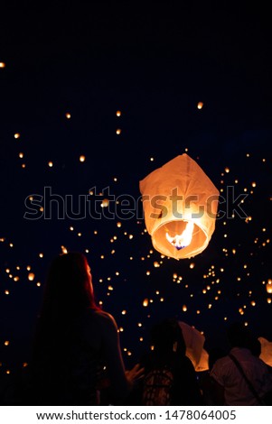 Lanterns are released into the night sky. 
