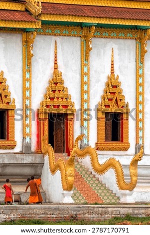  Laos. Monks work in front of a temple. Travel, culture and religion of Laos