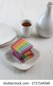 Lapis Pepe Rainbow, Colorfull Layered Indonesian Traditional Snack made from Steamed Rice Flour, Starch Flour, and Sugar. Served in Square White Plate with Tea - Shutterstock ID 1717144360