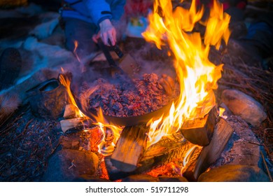 LAPLAND, SWEDEN - FEBRUARY 23, 2016: Campfire In Sami Tent, Frying Elk Meat For Traditional Food.